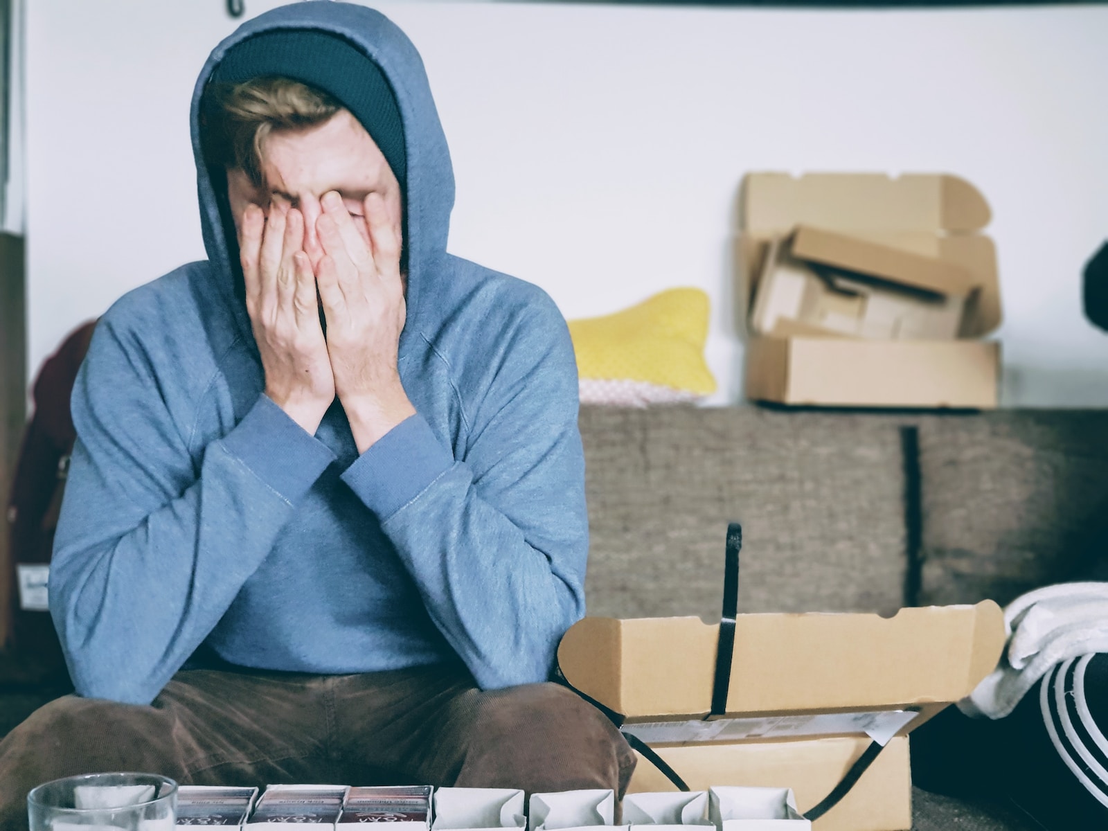 man covering face with both hands while sitting on bench